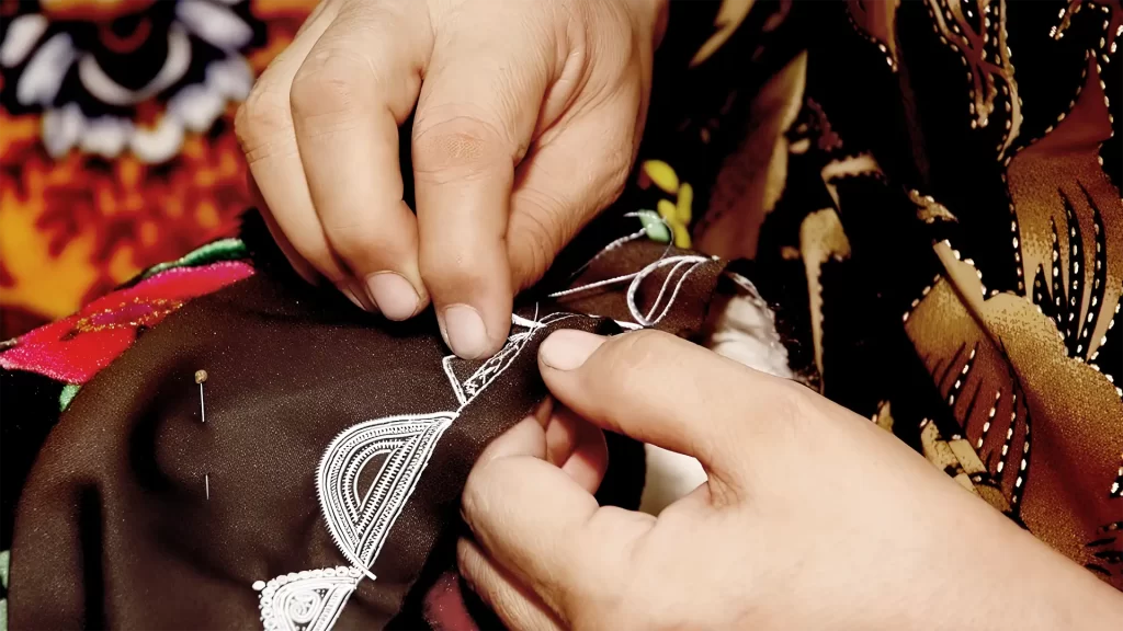 Мастер вышивает узор на тюбетейке в мастерской.
