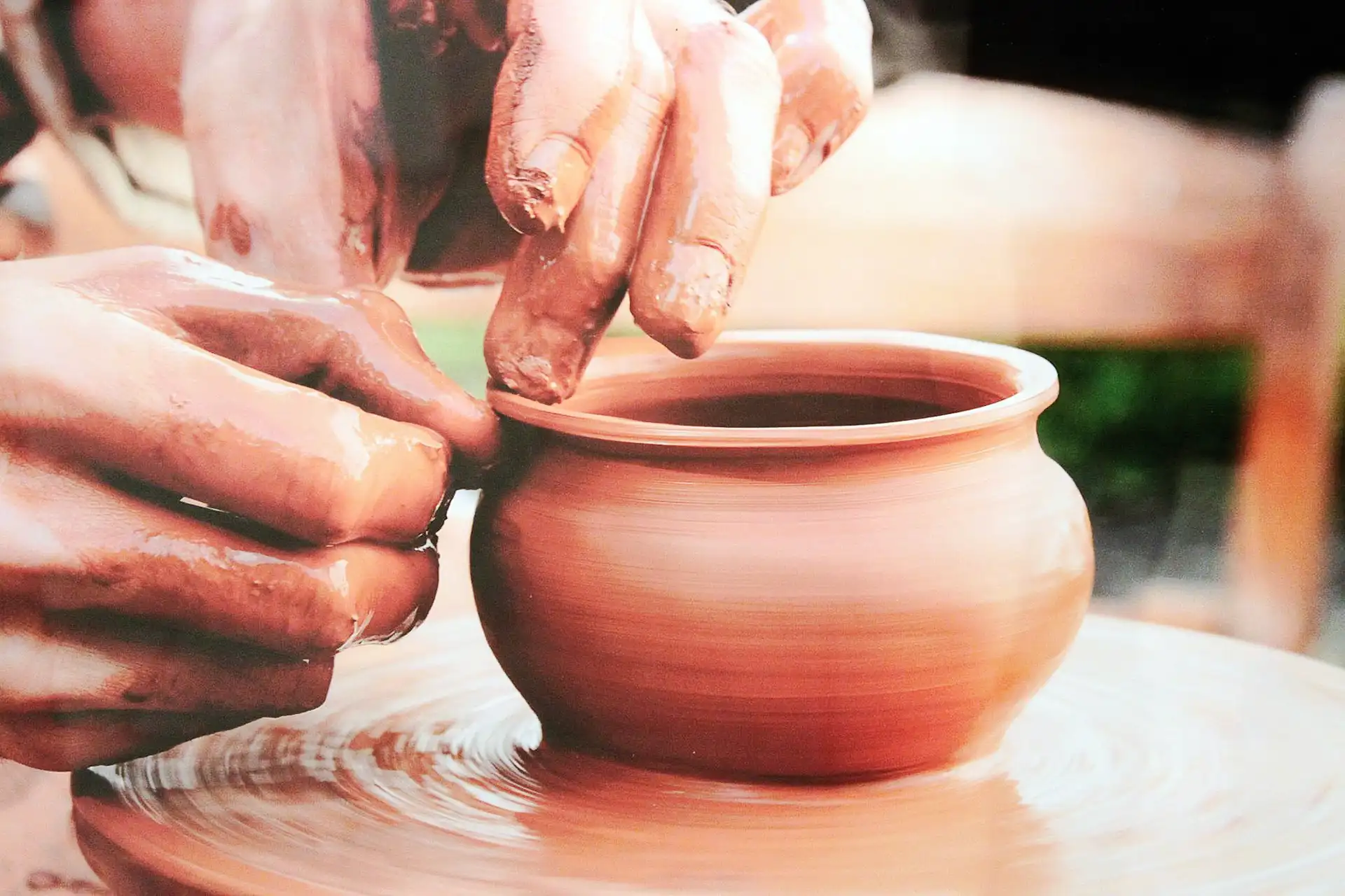 Мастер гончарного искусства за работой на гончарном круге, формирующий керамическое изделие