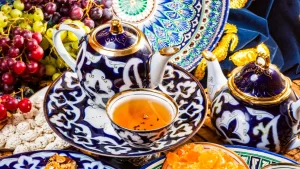 Традиционный узбекский чайный набор с чайником и пиалами, украшенными изысканным узором.